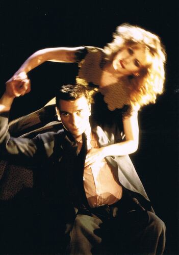 One figure seated holding another figure blurred in movement above him