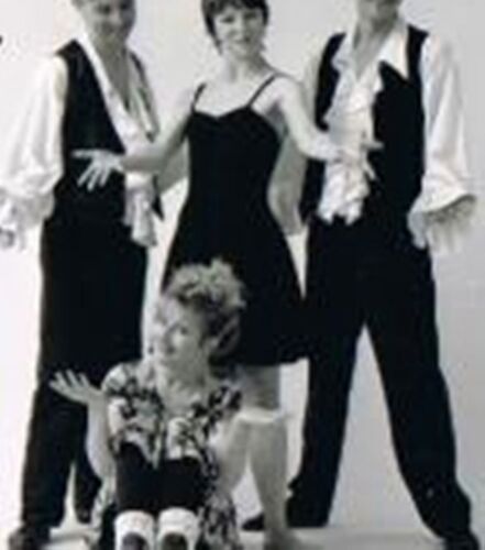 Three figures standing and one sitting for the camera in a white studio space in black and white