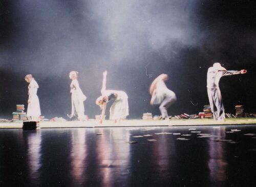 Five figures in line on a stage in movement