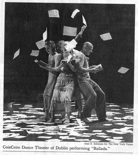 A newspaper clipping of three figures throwing sheets of paper above their heads on stage