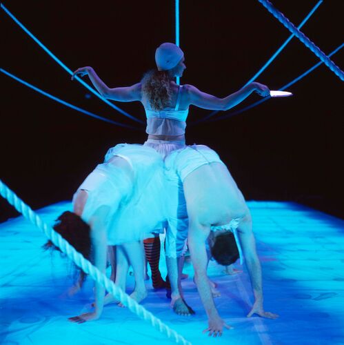 An ensemble with one figure facing away and others bent double towards the floor