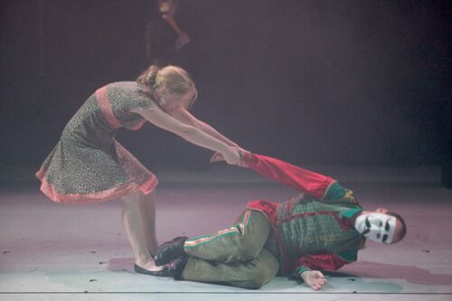 Two figures in movement with one on the floor and the other pulling from his arm