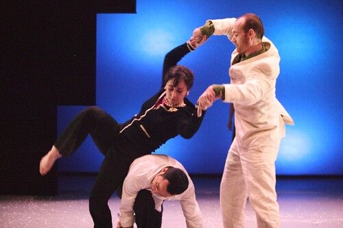 Three figures in movement with one rolling over another's back