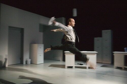 A figure airborne mid-leap in office dress