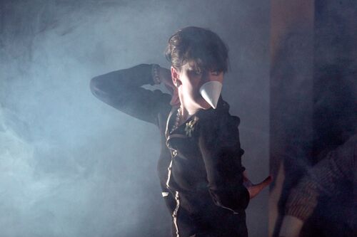 A figure in movement in side profile on a haze filled stage