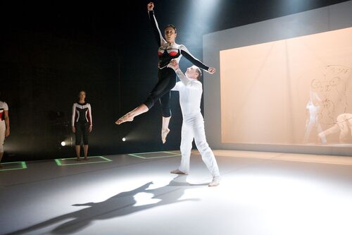 Two figures in movement mid-lift centre stage