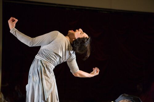 A figure leaning back with their mouth stretched open towards the ceiling