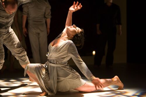 A figure in movement on the floor bending back to look upwards