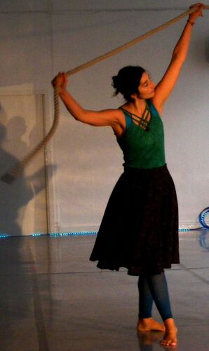 A participant in movement with a length of rope spread between their upstretched hands