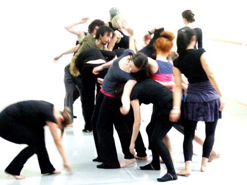 An ensemble of participants in movement in a studio