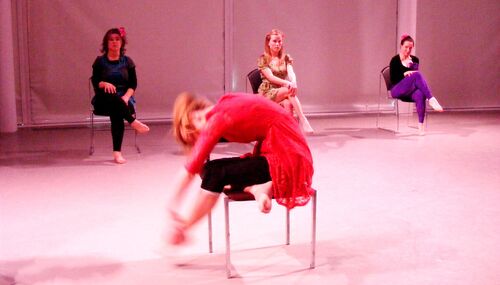 Three participants seated with one other to the front in movement on a chair