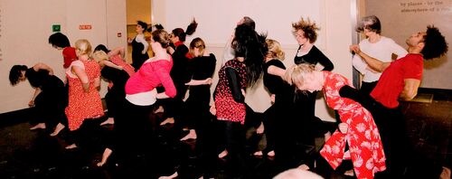 An ensemble of participants in movement in a gallery space