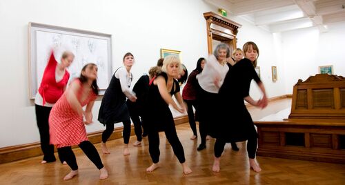 An ensemble of participants in movement in a gallery space
