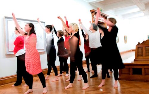 An ensemble of participants in movement in a gallery space