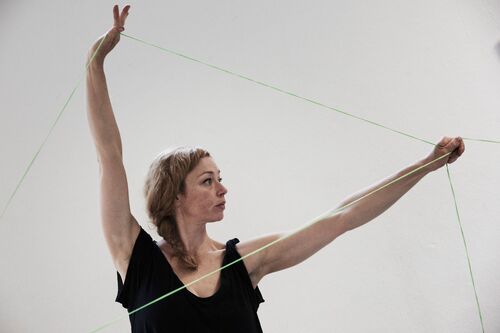 A figure with arms outstretched holding connecting threads