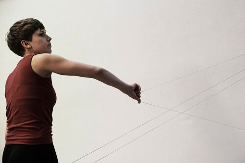 A figure holding threads extending from their hands