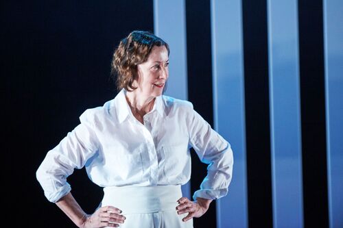 A figure dressed in white standing with hands on hips