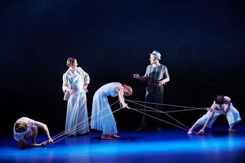 Three figures in movement with thread stretching between their hands and two figures behind them