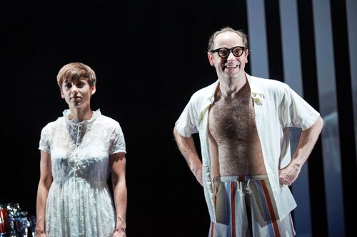 Two figures dressed in white standing on stage