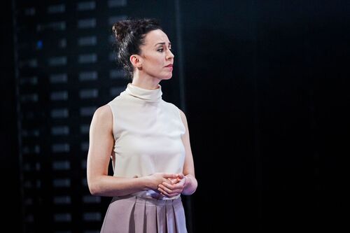 A figure standing lit on stage