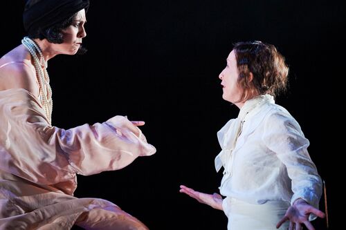 Two figures facing each other on stage