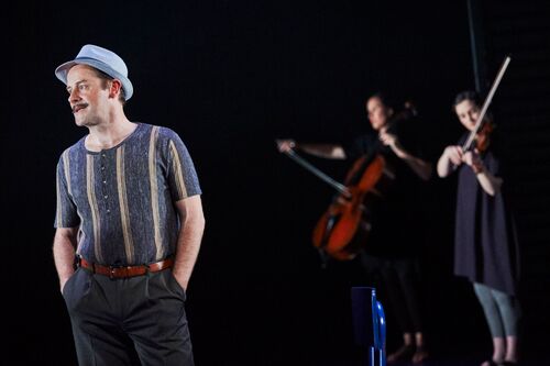 A figure standing with two musicians in the background