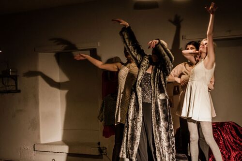Four women in movement with shadows cast behind them