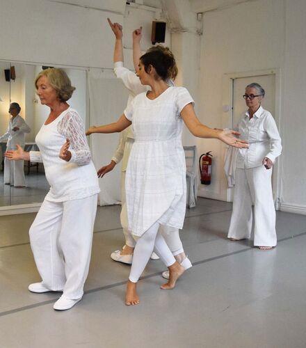 Four participants dressed all in white in movement together