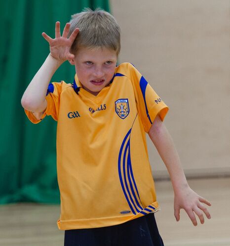 A young boy with hands in the shape of claws and a growl on his face