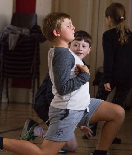 Two young boys in movement on the floor