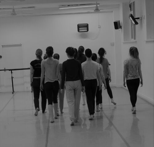 Participants walking with backs to the camera in a studio space