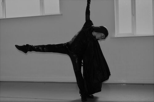 A figure in a Darth Vader costume in movement in a studio