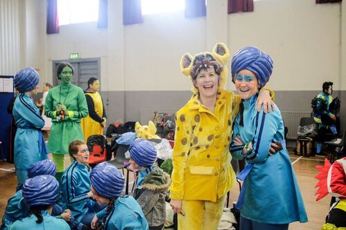 A group of participants gathered in a hall in different costumes
