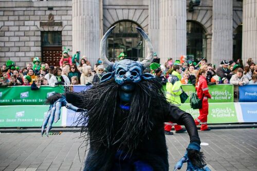 A figure in a blue monster mask in the St Patrick's Day Parade