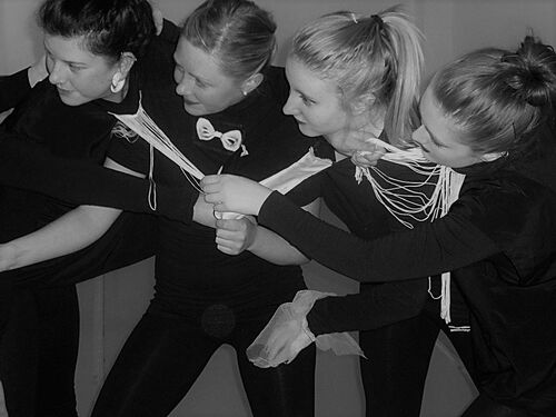 Four participants in movement holding strands of string