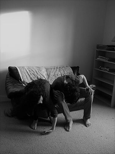 Two participants seated on a couch hunched over their knees in black and white