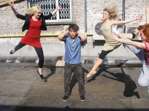 One participant standing with hands over their ears with three others mid-leap towards them