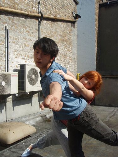 Two participants in movement together with one reaching towards the camera