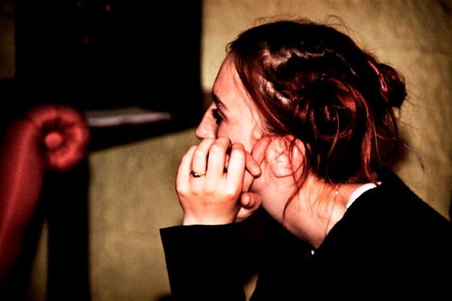 A close up of a participant in side profile leaning their face into a hand