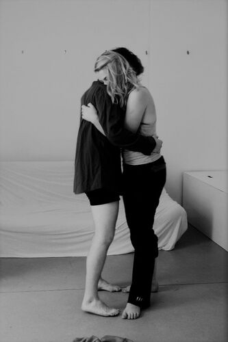 Two participants in an embrace in black and white