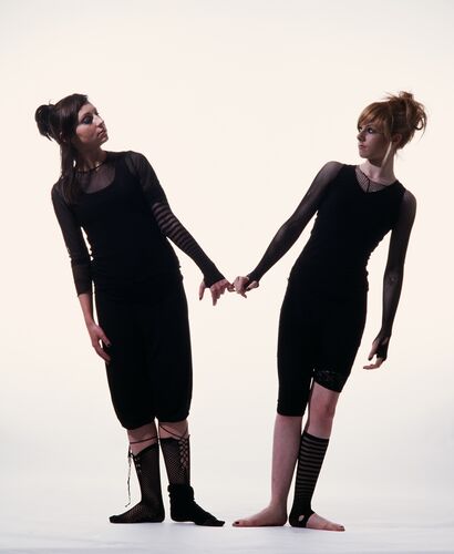 Two participants in black on a white background leaning away from each other