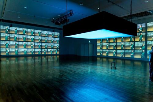 An empty gallery space with projections along all walls