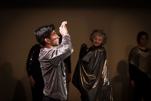 Participants in movement costumed in silver fabrics