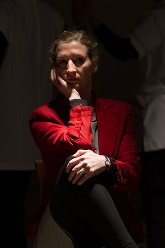 A participant sitting with one knee crossed over the other and her face in one hand