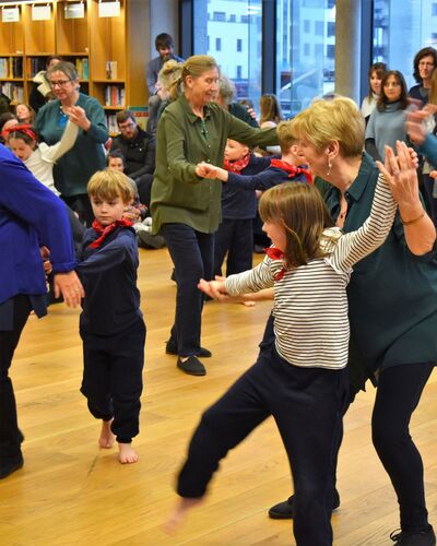Young and older participants in movement together in an open library space