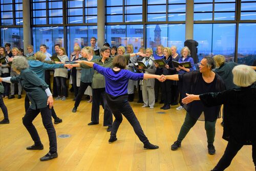 Older participants in movement with others lined up behind