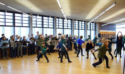 Older participants in movement with others lined up in the background