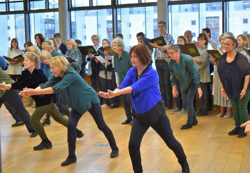 Older participants in movement with others lined up behind