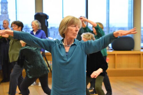 A participant in movement with arms stretching to the sides