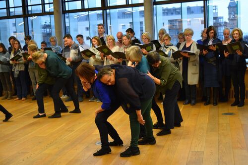 Older participants in movement with others standing behind
